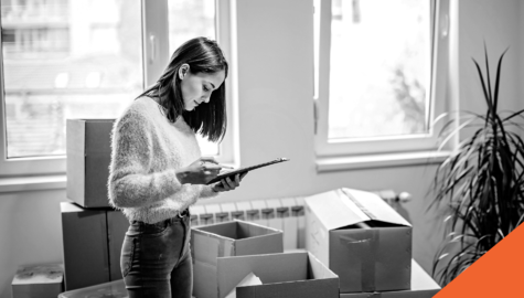 girl checking a list while packing boxes in her home