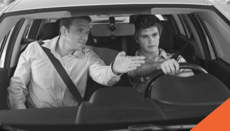 parent teaching his child to drive from the passenger seat